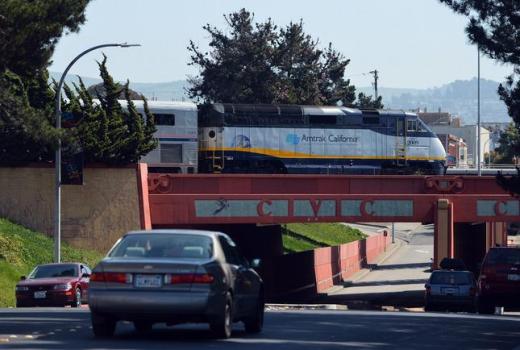 An Amtrak train passes over cars traveling on Macdonald Ave. as it departs the station in Richmond, Calif. on Monday, March 24, 2014. The tracks that carry Amtrak Capitol Corridor trains through more than a dozen East Bay and South Bay cities could become a rail superhighway for crude oil transports under a plan by Phillips 66. (Kristopher Skinner/Bay Area News Group)