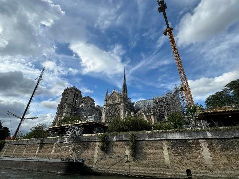 A building under construction with a crane Description automatically generated