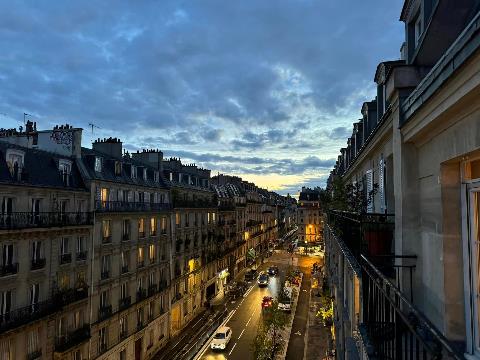 A street with buildings and cars on it Description automatically generated