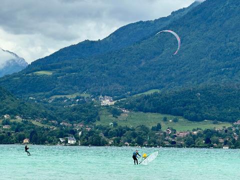 A person on a surfboard in the water with a kite in the air Description automatically generated