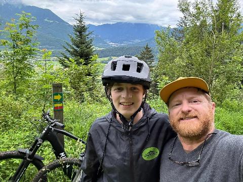 A person and child with a bicycle Description automatically generated